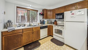A kitchen with wooden cabinets, a white refrigerator, a microwave, an oven, and a dishwasher. - 2 Townhomes + Indoor Pool + Game Room | Gore Mtn | The Summit at Gore Mtn (North Creek)