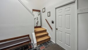 A staircase with carpeted steps leading to a white door with a small window. - 2 Townhomes + Indoor Pool + Game Room | Gore Mtn | The Summit at Gore Mtn (North Creek)