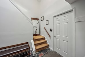 A staircase with carpeted steps leading to a white door with a small window. - 2 Townhomes + Indoor Pool + Game Room | Gore Mtn | The Summit at Gore Mtn (North Creek)