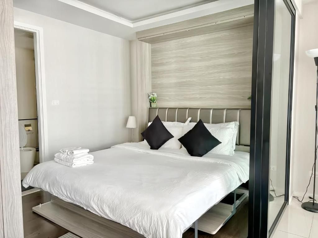 Ein Hotelzimmer mit Bett, Nachttisch, Lampe und Blick ins Freie.