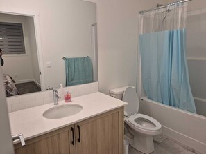 Ein Badezimmer mit Waschbecken, Toilette und Duschvorhang.