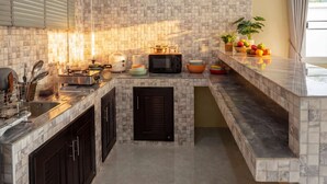 A modern kitchen with a tiled backsplash, a built-in oven, a microwave, and a variety of kitchen utensils.