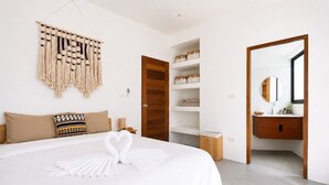 Een hotelkamer met een groot bed, een houten deur, een inbouwkast en een spiegel.