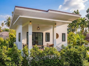 A modern two-story building with a covered porch, large windows, and a central entrance.