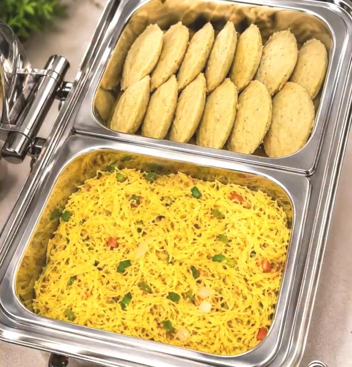 Un buffet avec deux plateaux de nourriture : l’un contient des petits pains et l’autre, un plat de riz jaune.