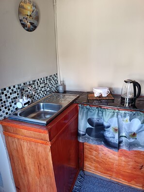A kitchen with a sink, a kettle, and a coffee maker. - 11 on High Airbnb za (Steynsburg)