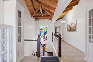 A hallway with a wooden ceiling, white walls, and a stained glass window. - Villa Dama del Mar,, (Cabarete)