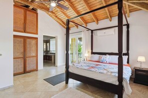 A four-poster bed with a canopy, a bathroom with a shower, and a view of the outdoors. - Villa Dama del Mar,, (Cabarete)