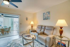 A modern living room with a sofa, two lamps, a coffee table, and a painting on the wall.