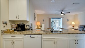 A kitchen with white cabinets, a coffee maker, a sink, and a ceiling fan. - 4 Mi to Beaches! Family Getaway w/ Pool in Venice (Venice)