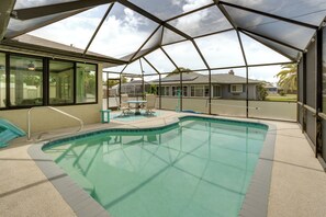 Una piscina interior con zona cubierta, agua cristalina y vistas al exterior.