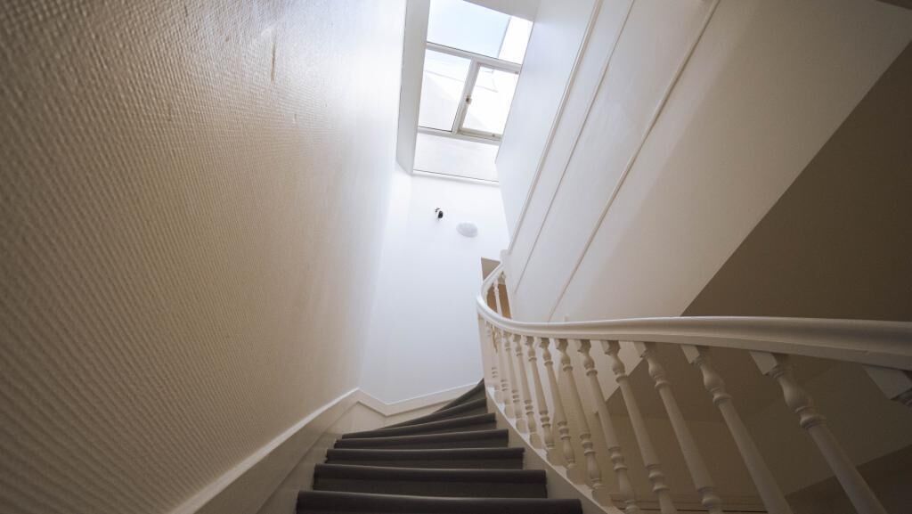 Eine Treppe mit weißen Balustraden und einem Oberlicht am oberen Ende.