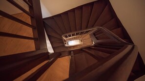 A wooden spiral staircase with a metal handrail and a light fixture at the top. - Ito's Retreat - Awakening the Senses Under the Roofs (Tours)