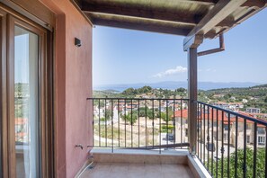 Un balcón con vistas a una zona residencial y montañas distantes.