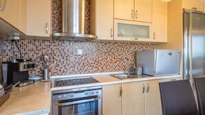 Una cocina moderna con electrodomésticos de acero inoxidable, un microondas y un horno empotrado.