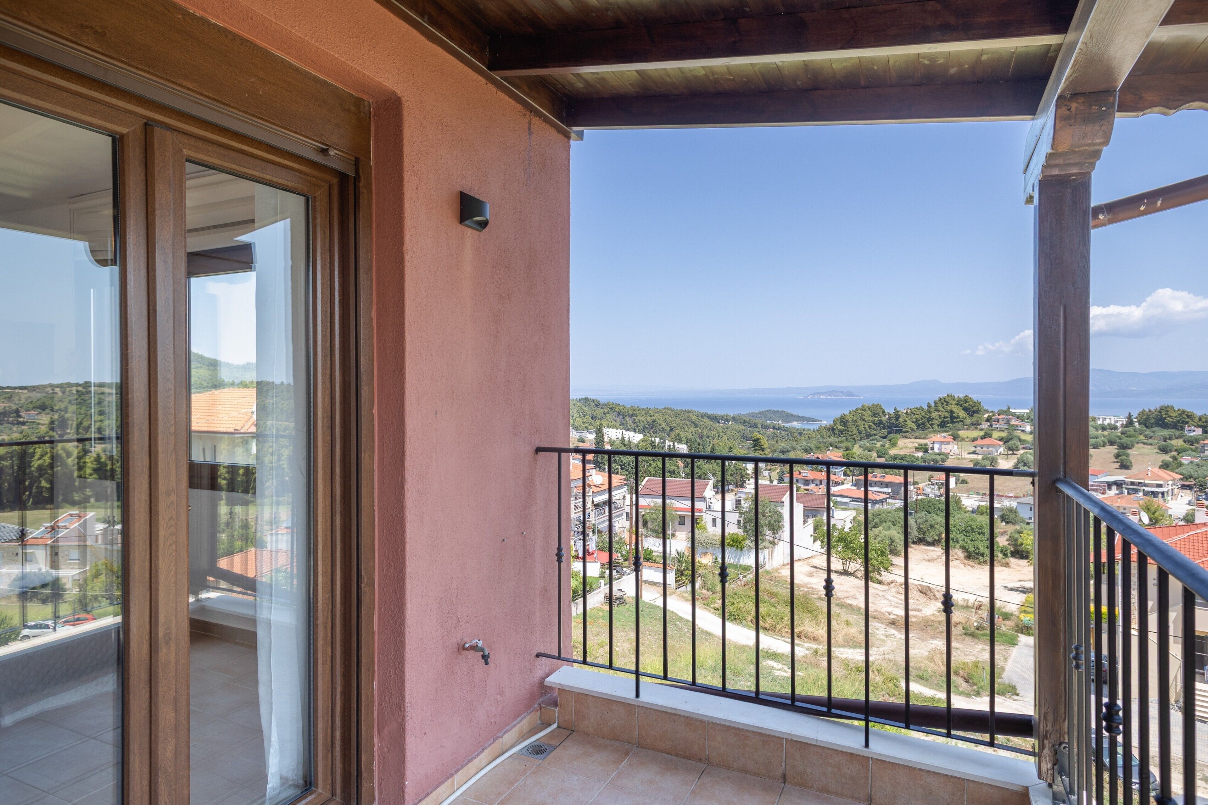 Ein Balkon mit Blick auf ein Wohngebiet und ferne Berge.