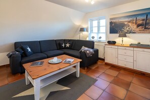 Ein Wohnzimmer mit einer Couch, einem Couchtisch und einem Schrank.