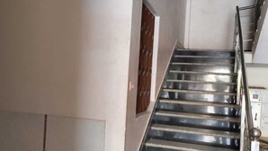 Een trap met metalen leuningen en een handrail, die leidt naar een verdieping.