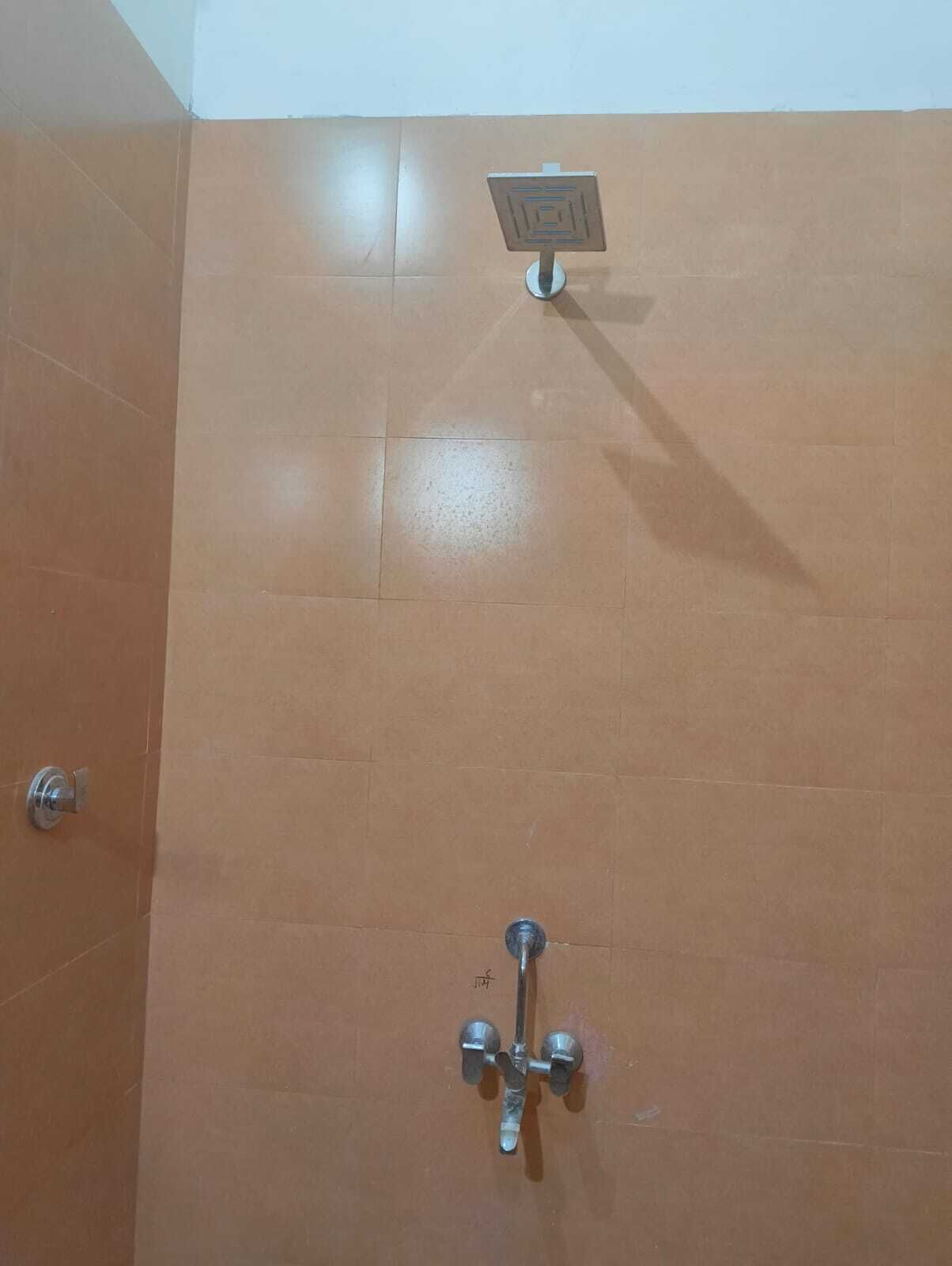 A bathroom with a shower, a toilet, and a sink.