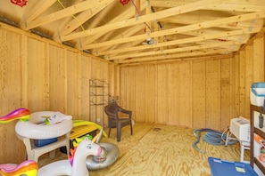 A room with wooden walls and ceiling, a chair, inflatable toys, and a heater. - Family Getaway w/ Pool on 8 Acres in Carriere! (Carriere)