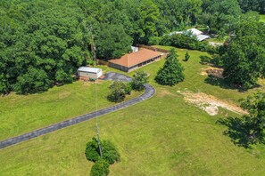 An aerial view of a residential property with a large house, a smaller shed, and a winding driveway. - Family Getaway w/ Pool on 8 Acres in Carriere! (Carriere)