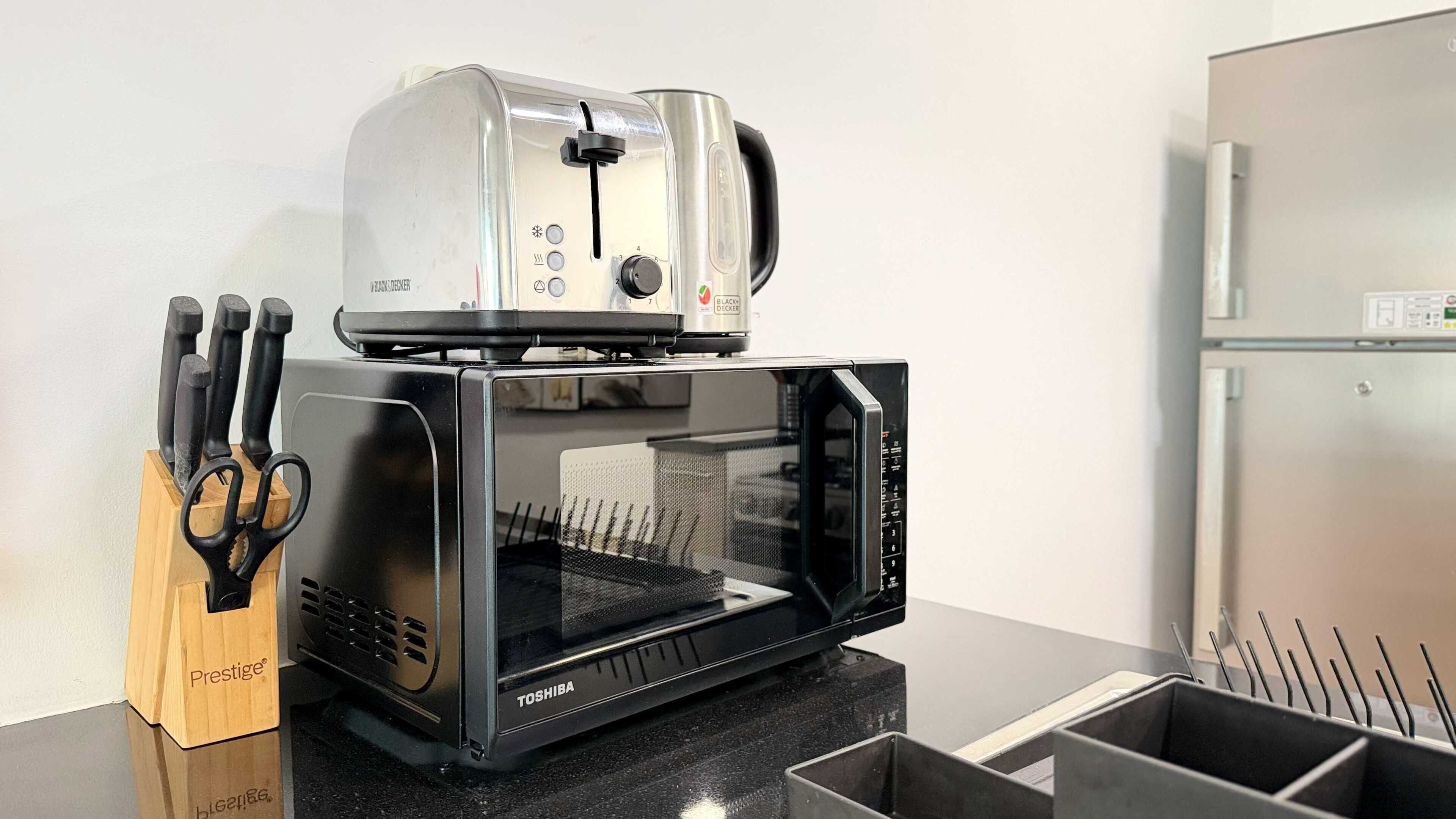 A kitchen with a toaster and a microwave oven.