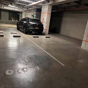 A parking garage with a car parked in a spot marked with the number 2. - Premium Loft with AC  Panoramic View in Laureles (Medellín)
