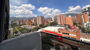 A cityscape with high-rise buildings, a clear sky, and mountains in the background. - Premium Loft with AC  Panoramic View in Laureles (Medellín)