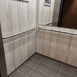 A corner of a room with wooden panel walls and a tiled floor. - Premium Loft with AC  Panoramic View in Laureles (Medellín)