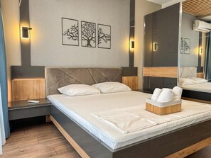 Ein modernes Hotelzimmer mit einem gro ßen Bett, einem Nachttisch und einer Wand-Klimaanlage.
