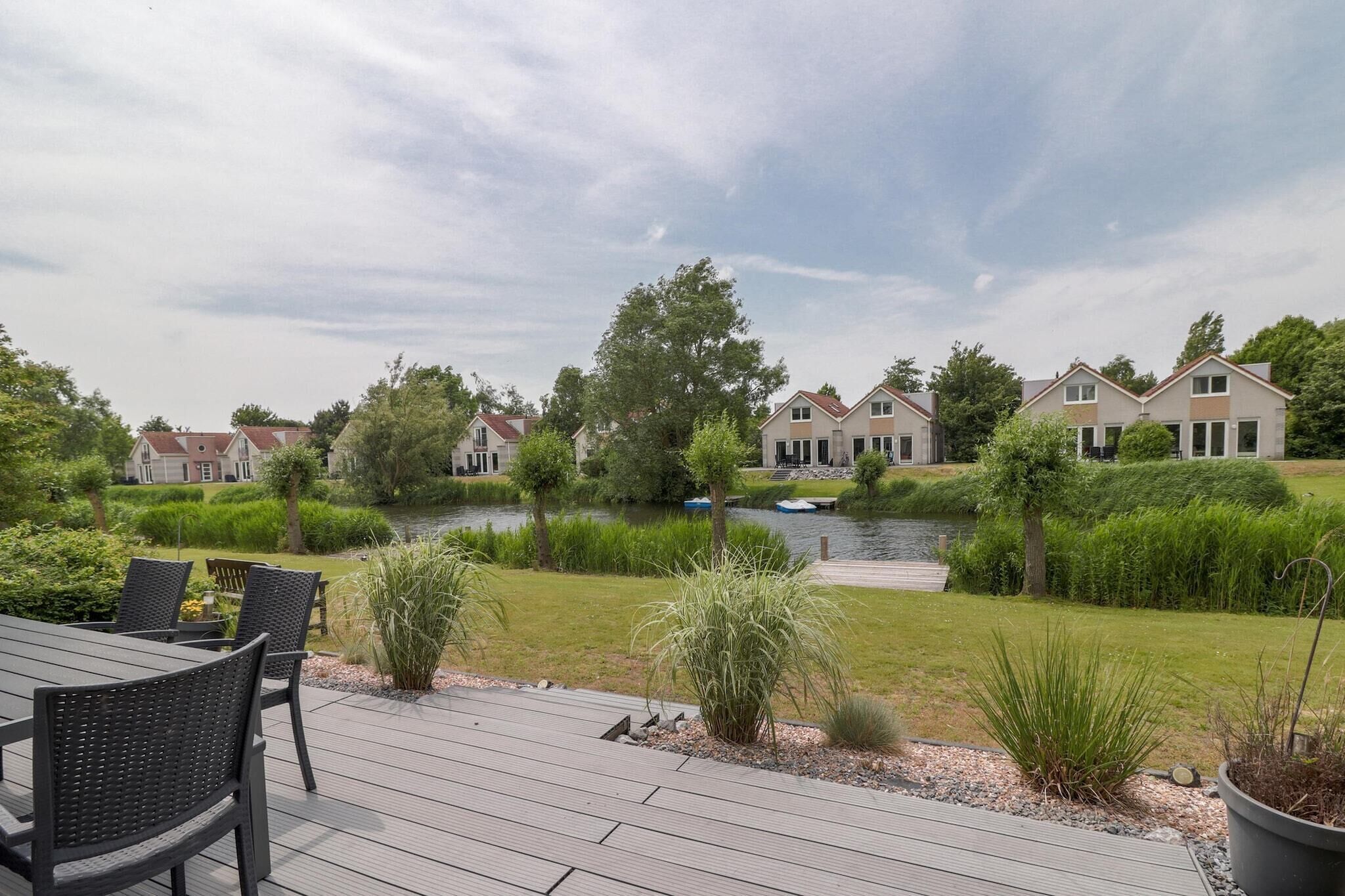 A residential area with houses, a river, and a deck with chairs.