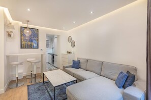 Ein modernes Wohnzimmer mit einer Couch, einem Couchtisch und Barhocker.