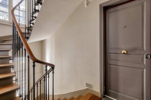 Eine Treppe mit Holzhandläufen und einer dunklen Tür mit Messinggriff.
