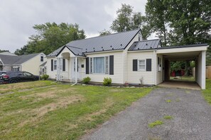 A single-story house with a covered porch, a driveway, and a parked car.