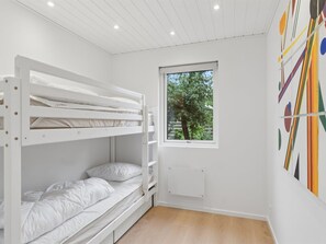 Habitación con literas para niños, ventana y radiador.