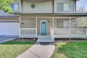 A two-story house with a front porch, a garage, and a blue door. - 9 Mi to Smith Rock SP! Family Home w/ Fenced Yard (Redmond)