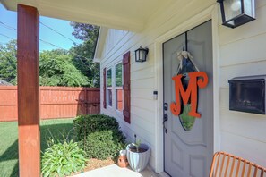 A house with a porch, a mailbox, and a wooden fence.