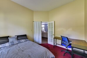 Ein Schlafzimmer mit einem Bett, einem Schreibtisch und einem Stuhl.