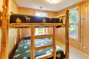 A bunk bed with a wooden frame and a quilt with animal prints. - Mille Lacs Lake Cabin w/ Private Dock & Fire Pit (Garrison)