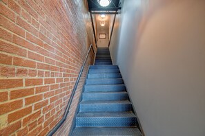 A staircase with a metal handrail leading to a door at the top.