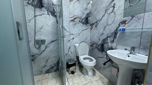 A bathroom with a glass-enclosed shower, a toilet, and a sink. - Sultan hotel boutique (Andijan)