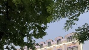 Un hotel de varios pisos, con una escalera central e iluminación en la fachada.