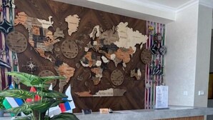 Un mostrador de recepción con detalles de madera y un fondo con un mapa mundial.