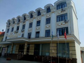 A hotel with a grand facade, multiple windows, and a sign indicating it is a hotel and spa.