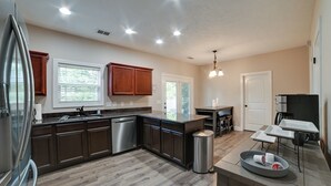 Una cocina moderna con armarios de madera oscura, electrodomésticos de acero inoxidable y una isla central.