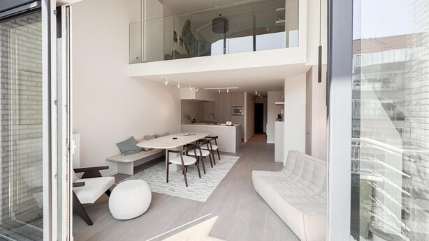 Ein modernes Interieur mit Essbereich, Sitzgelegenheiten und einer Küche.