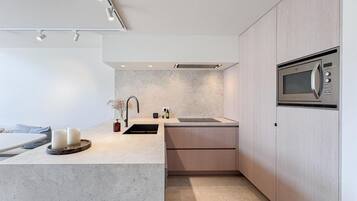 Een moderne keuken met een ingebouwde magnetron, een spoelbak en een aanrecht met kaarsen.