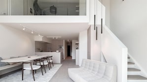 Ein modernes Interieur mit Essbereich, Sofa und Treppe.