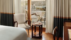 A hotel room with a bed, a round table, two chairs, a balcony with a view of a cityscape, and curtains. - Nazenin Hotel (Istanbul)
