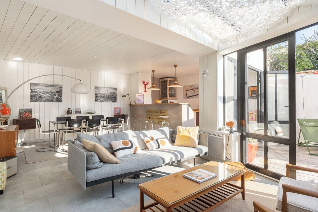 A modern living room with a sofa, coffee table, and dining area.